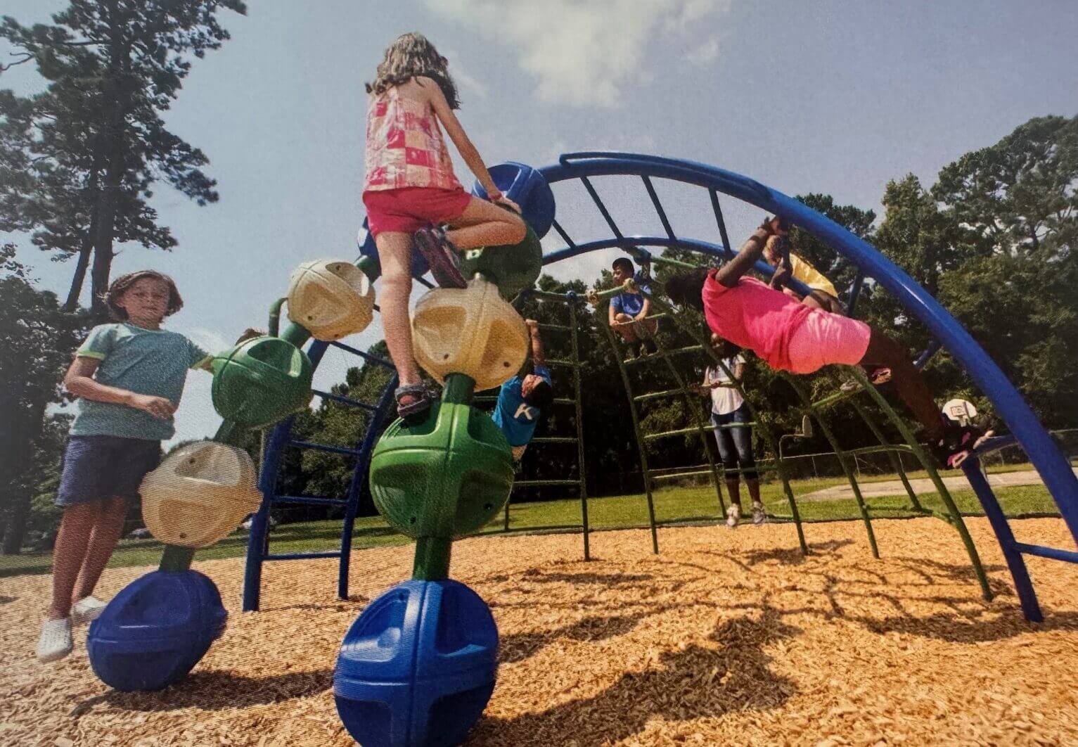 Children playing energetically on a jungle gym outdoors.